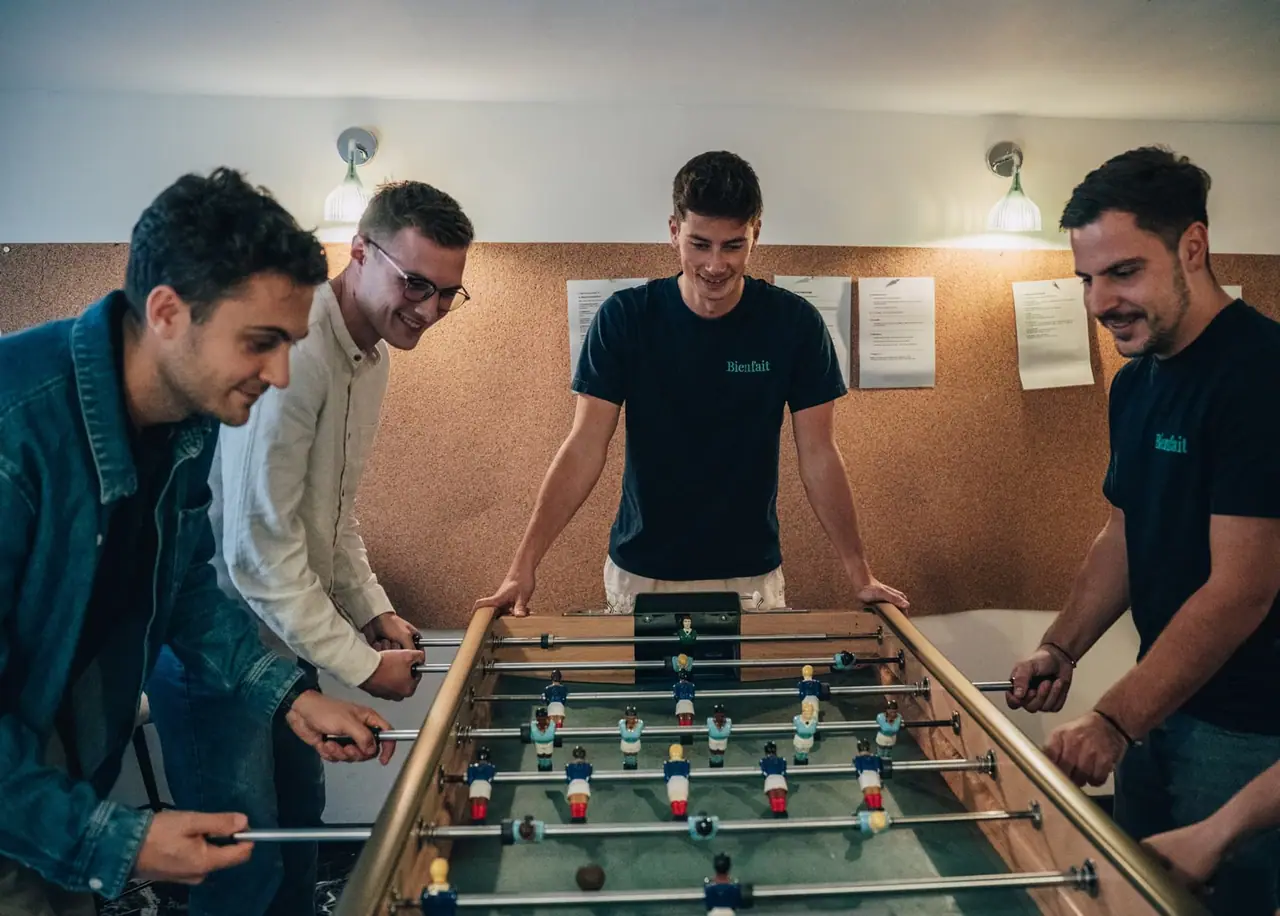 Quatre membres de l'équipe Bienfait autour d'un babyfoot
